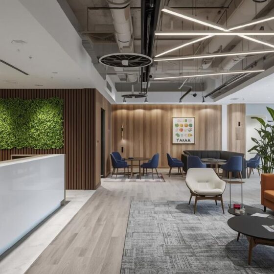 Modern office reception interior with wooden wall panels, green wall, and luxury lighting.